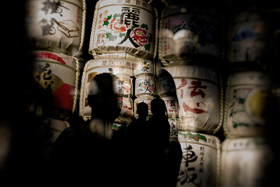 silhouette of couple in front of sake barrels