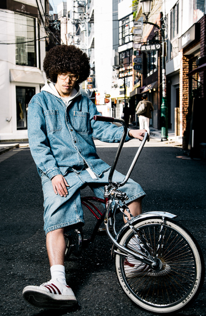 Japanese man with afro on low rider bike