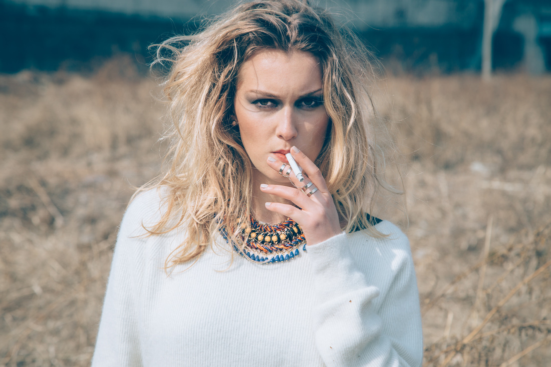 women's fashion smoking a cigarette with windblown hair