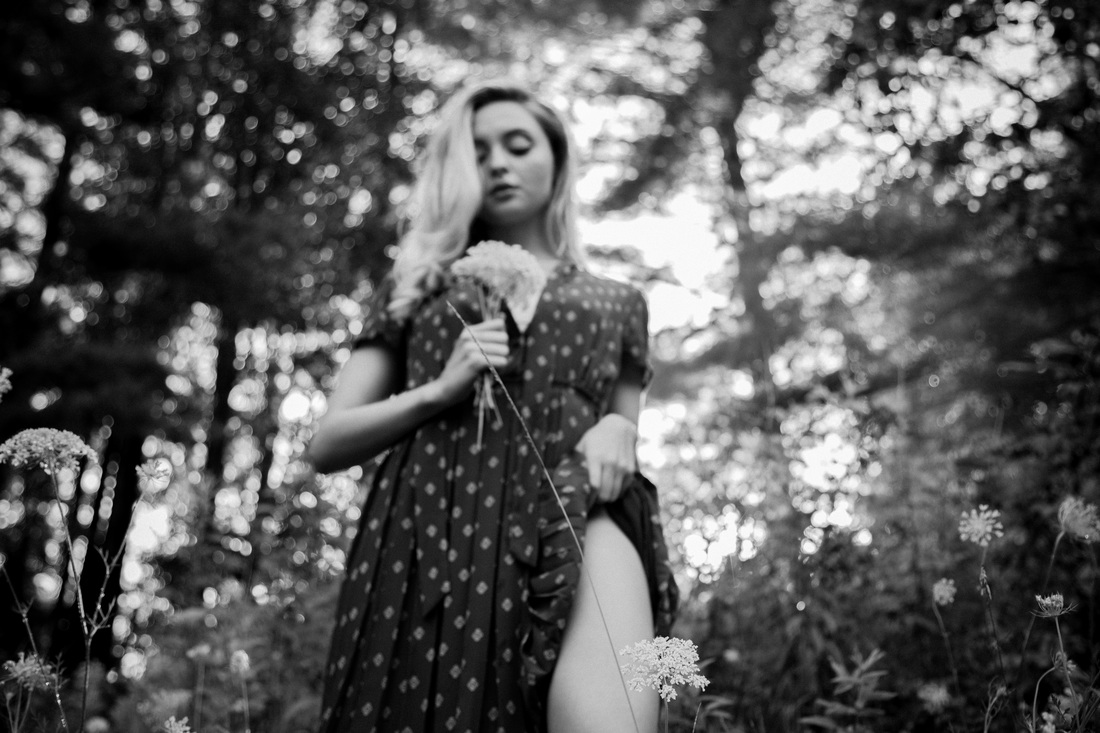 Allie pulling up her dress in a forest