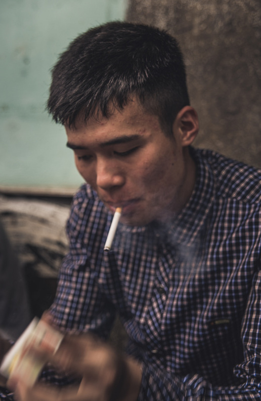 young vietnamese man lights his cigarette