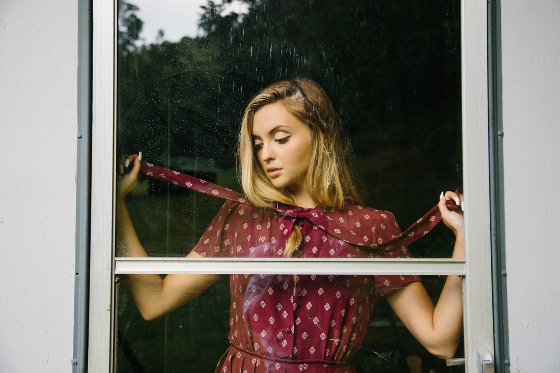 Portrait of Allie behind a glass door