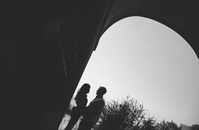 silhouette of couple under bridge