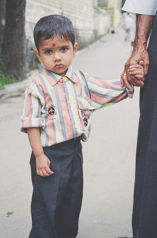 young hindu boy holding hand of father