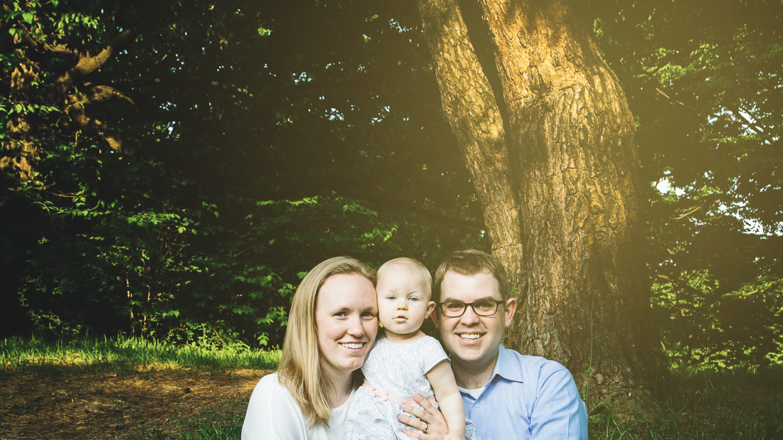 Family portraiture in nature with a sunburst coming through the trees
