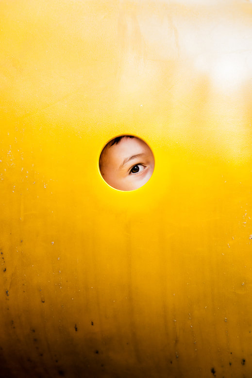 boy's eye peering through playground