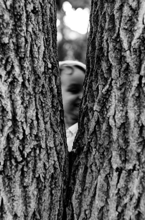 boy behind tree