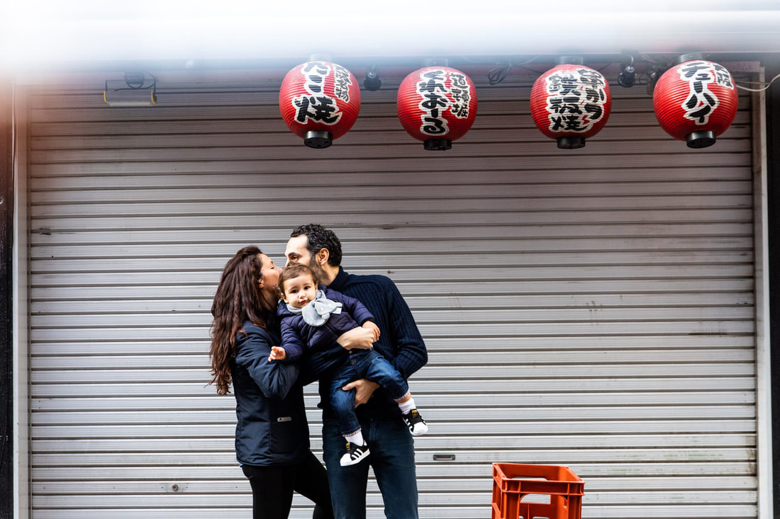 parents hold son in front of restaurant facade