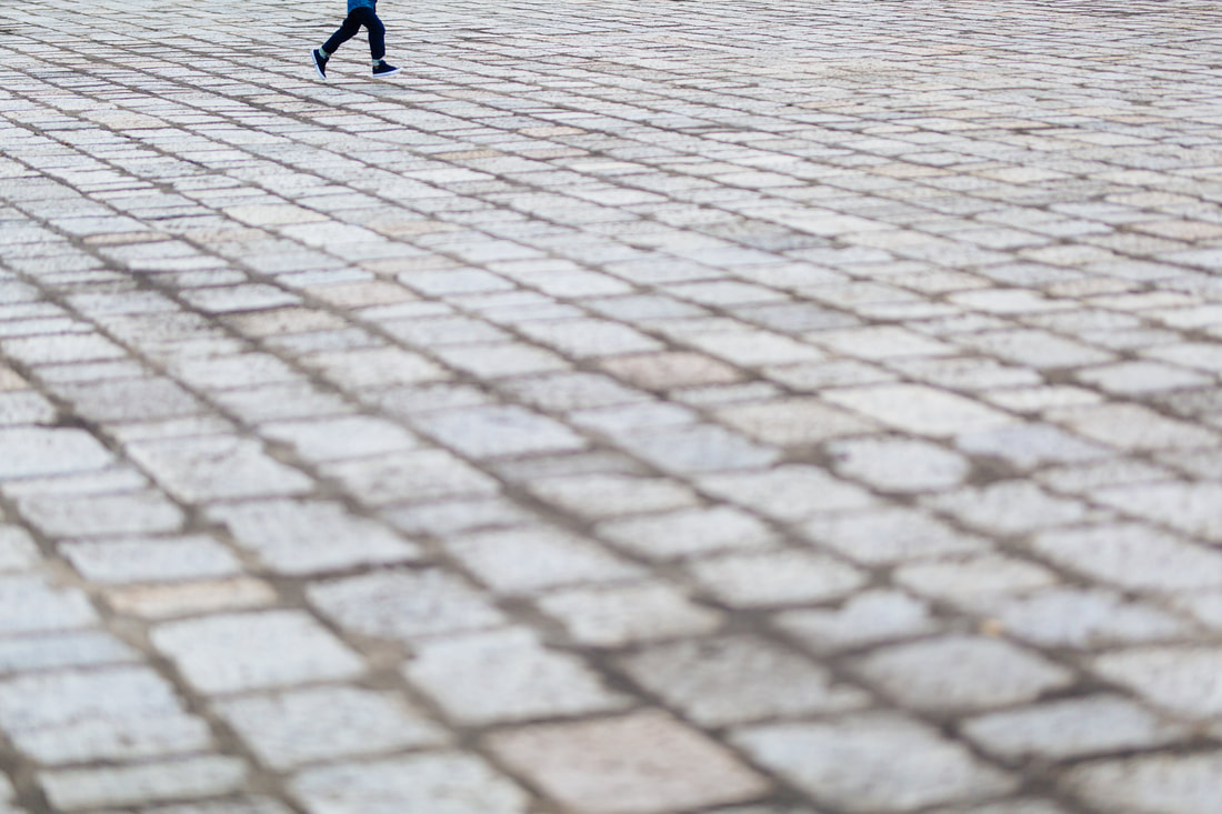 Child running on cobblestone