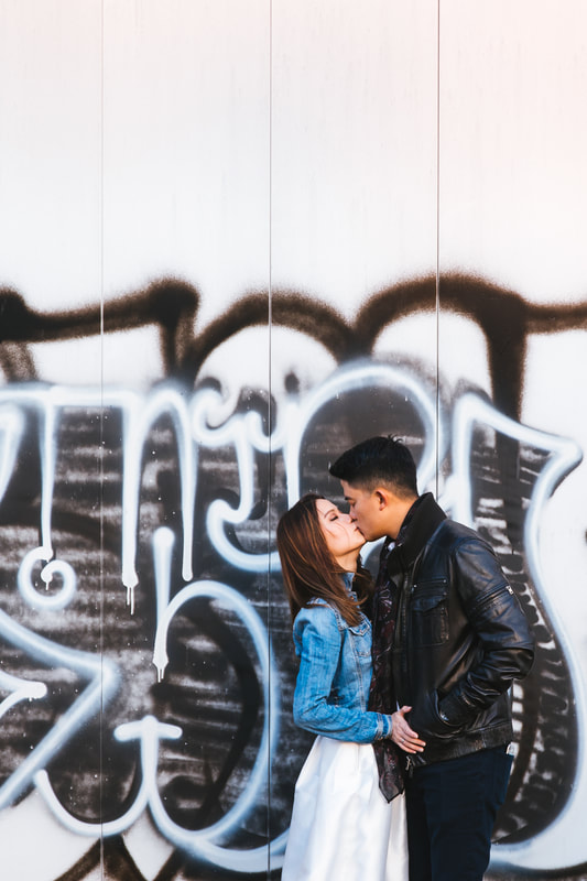 Couple kiss next to grafitti