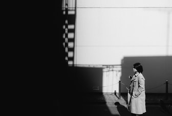 Woman in coat walks down street