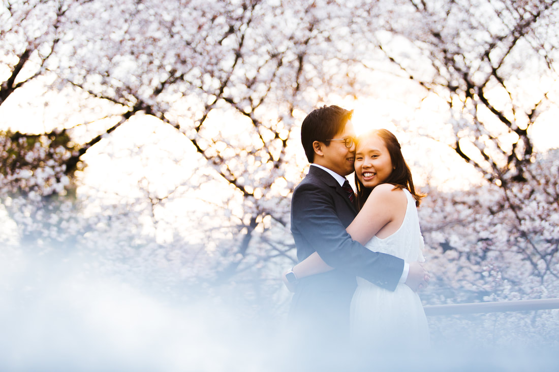 Natalie and Eugene hug near sakura trees