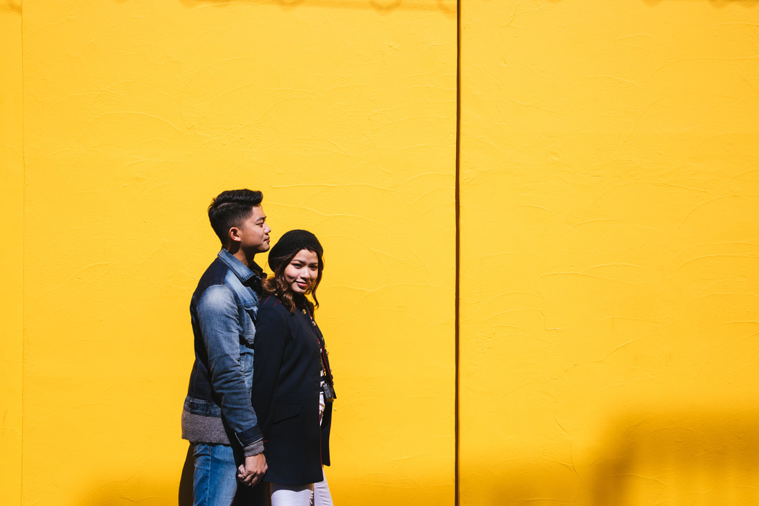 Engagement photo against yellow wall